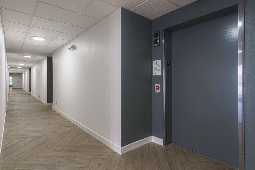 a hallway with gray and white walls and gray doors